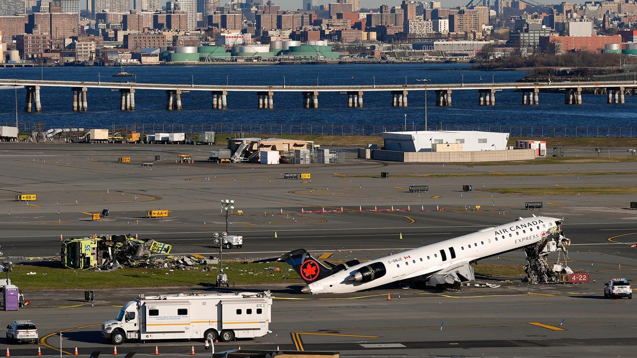An Air Canada Express jet and Port Authority fire truck lay on the side of a runway at LaGuardia Airport, Tuesday, March 24, 2026, after colliding with each other shortly after the jet landed in New York Sunday night. (AP Photo/Yuki Iwamura)