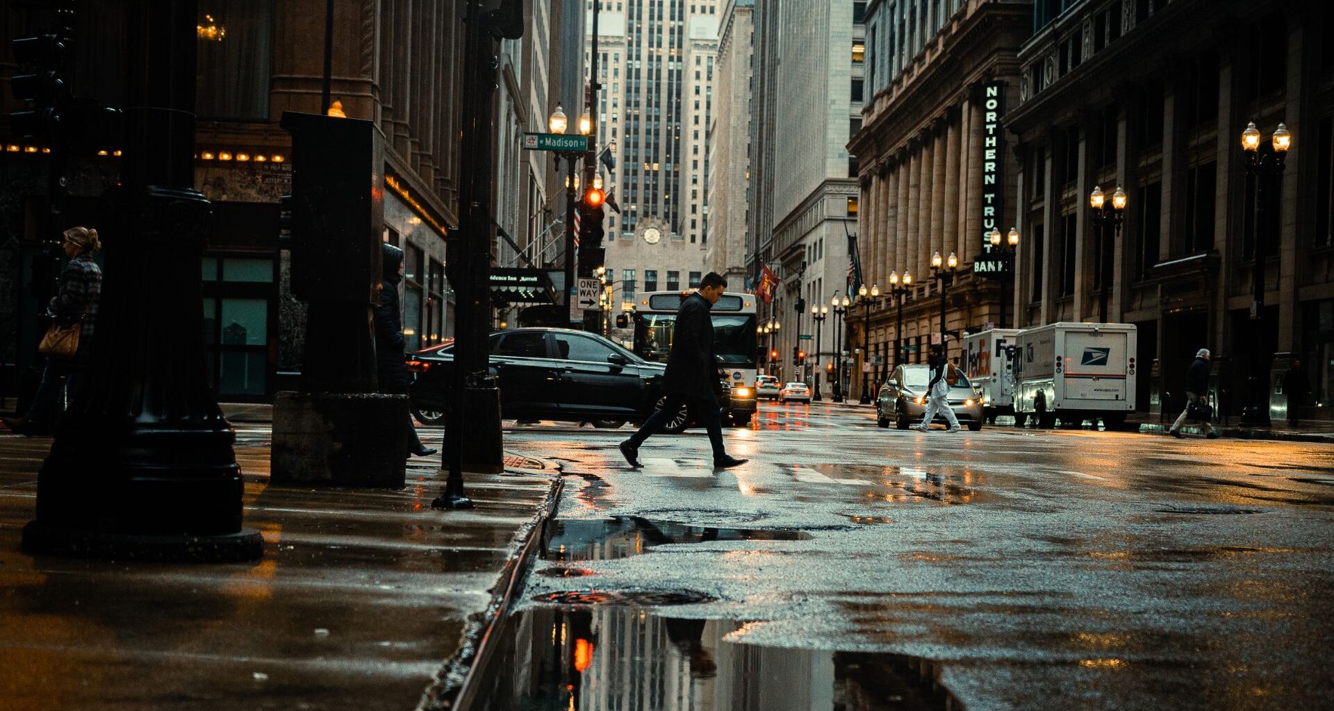 New York City street with pedestrian walking and cars driving by
