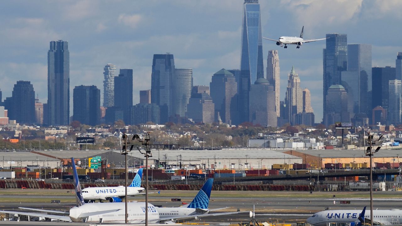 The New York City skyline is seen behind a plane approaching Newark International Airport in Newark, N.J., Thursday, Nov. 6, 2025. (AP Photo/Seth Wenig)