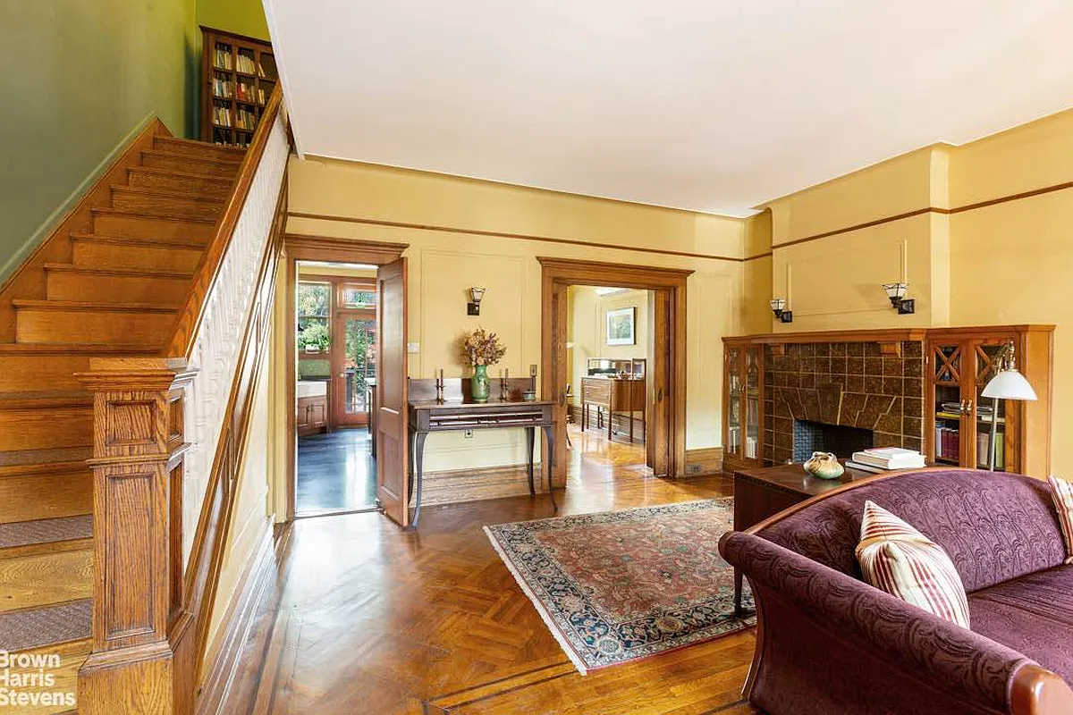 parlor with yellow walls, a mantel and built-in bookscases