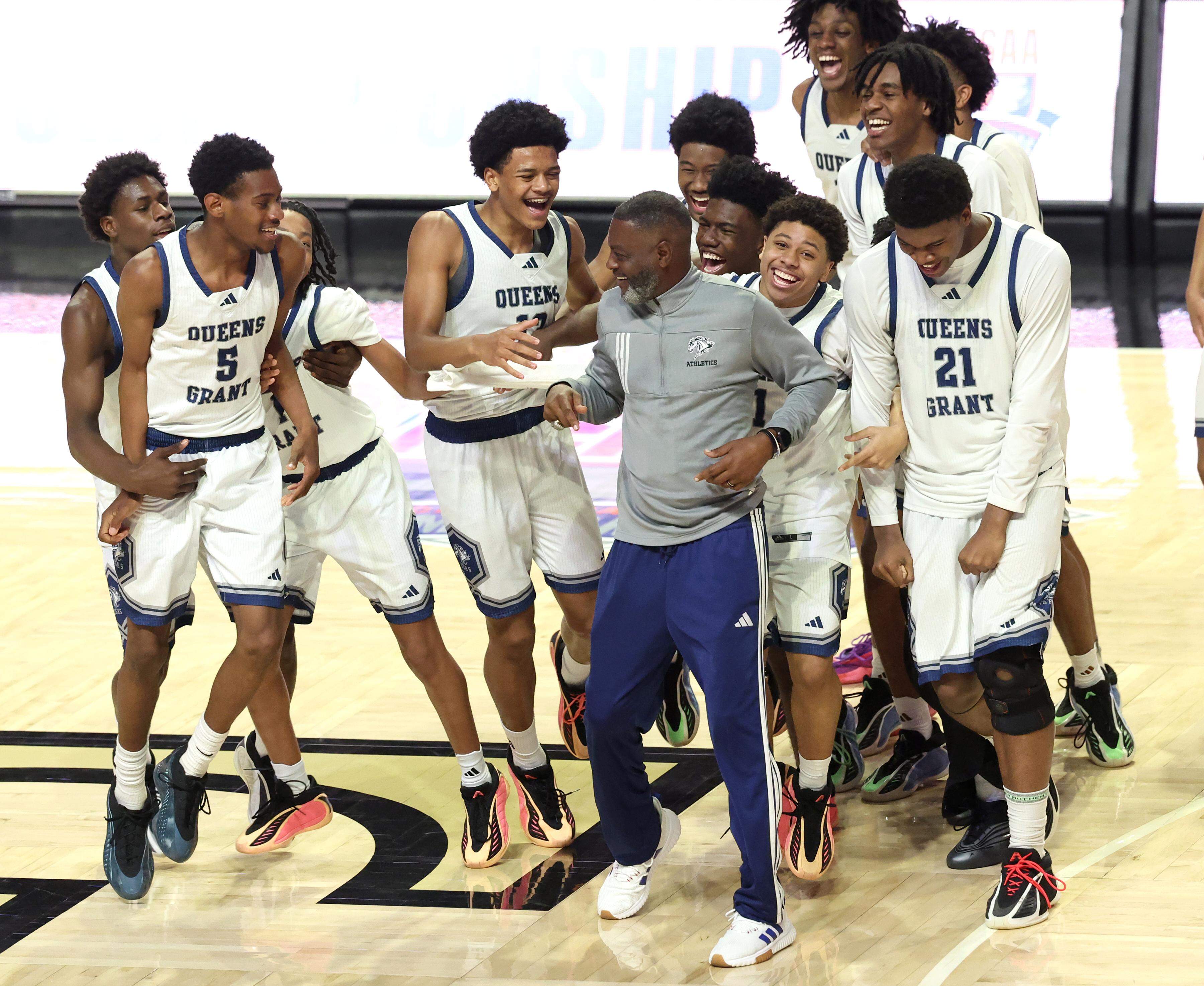 Queen’s Grant head boys basketball coach Joe Badgett, center, is pursued by his team to celebrate following their 77-43 win over Warren County in the NCHSAA 2A boys’ championship game at Lawrence Joel Veterans Coliseum in Winston-Salem, NC on Thursday, March 12, 2026.