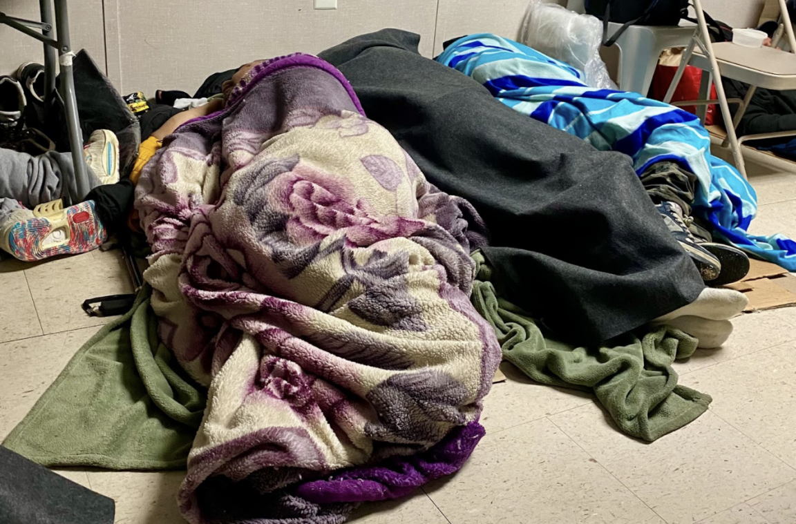 On Friday, February 6, people seeking warmth sleep on the floor of a trailer at Elmhurst Hospital. (Credit: A. Felix)