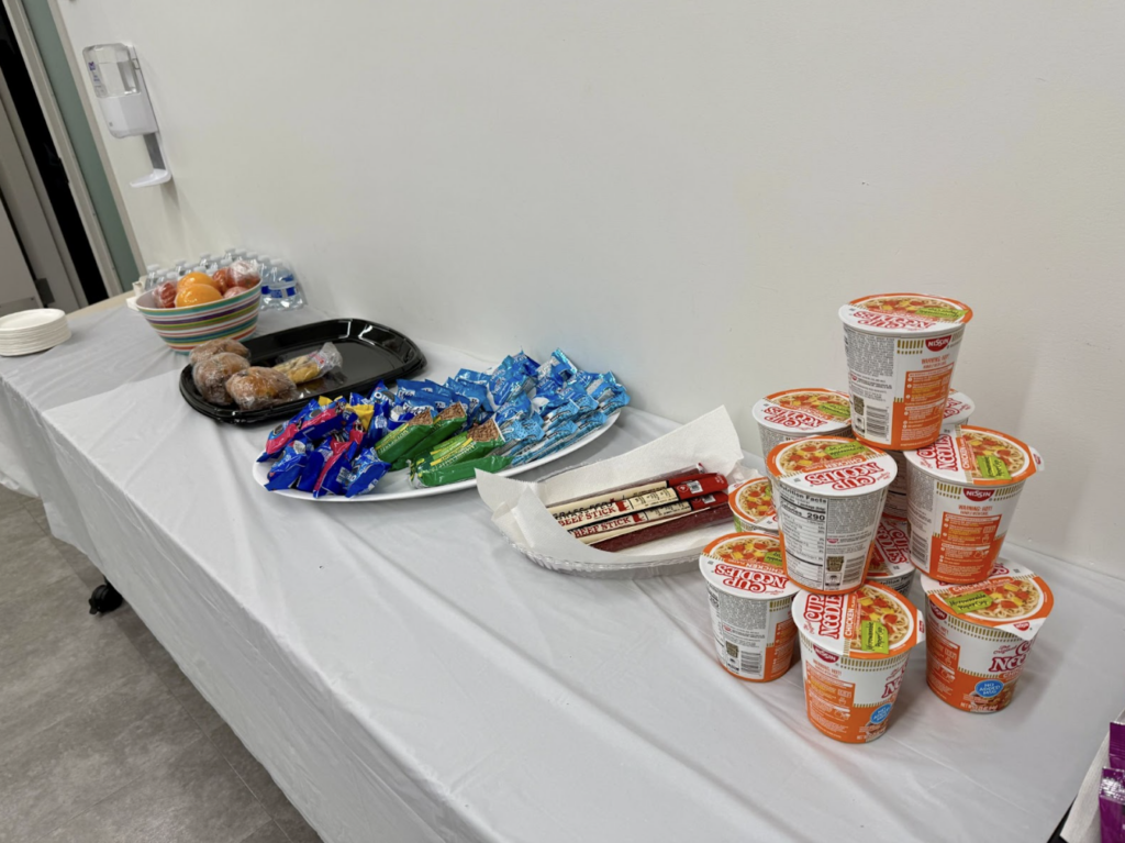At the Roosevelt warming center, run by NYC Health + Hospitals, a table offered visitors food and drinks, in stark contrast with the Elmhurst Hospital trailer. (Credit: A. Felix)
