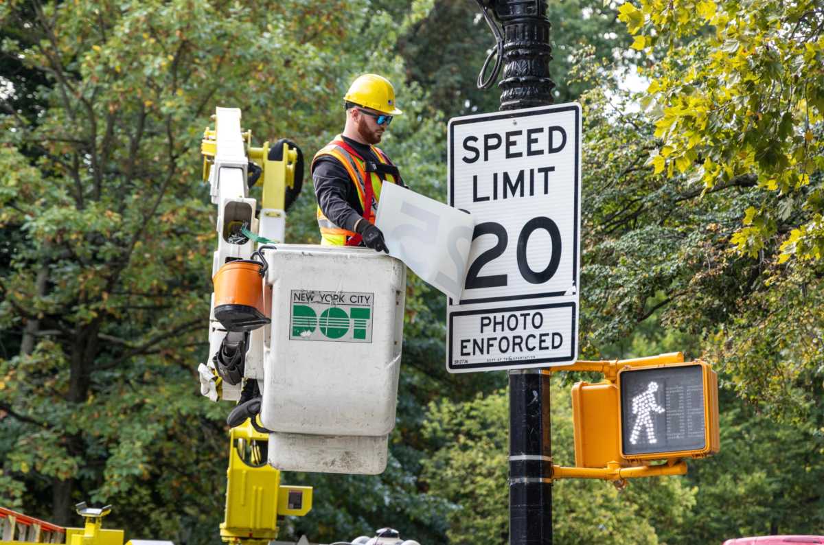 DOT worker changes speed limit sign in Brooklyn
