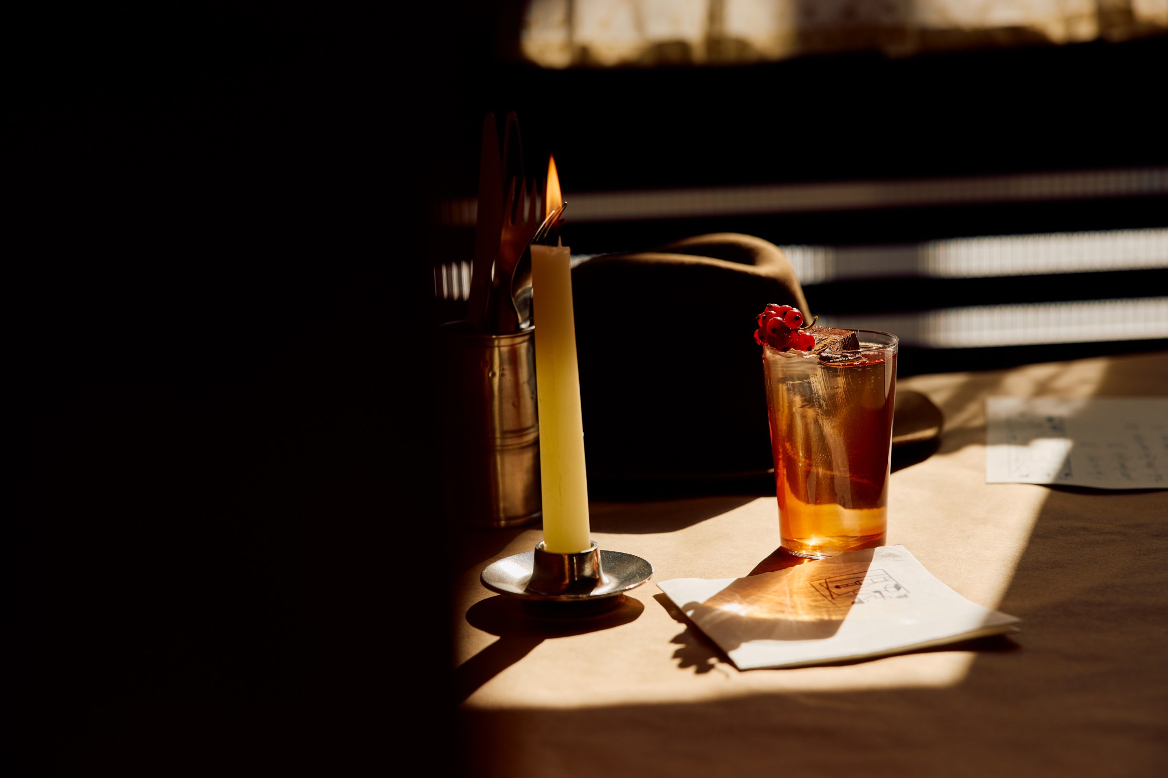 A cocktail in the shadows on a table.
