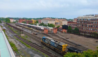 A map of Massachusetts with a cross of rail lines representing north-south Amtrak routes through the CT River Valley and east-west routes from Albany to Boston. The cross meets in Springfield. An icon in the lower right describes the vision as "Compass Rail: passenger rail for the Commonwealth of Massachusetts"
