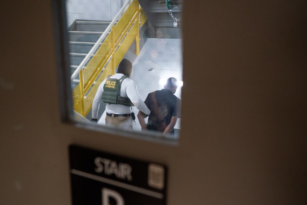 Federal law enforcement officers take a migrant into a stairwell after he was taken into custody inside the Jacob K. Javits Federal Building on Wednesday, July 23, 2025, in Manhattan, New York. (Barry Williams/New York Daily News)