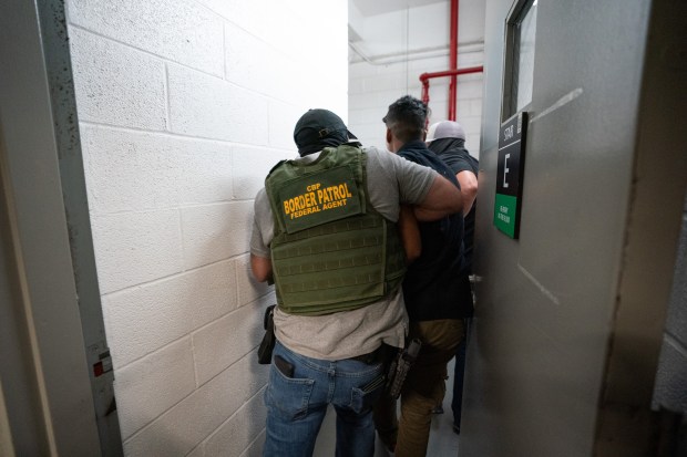 Federal law enforcement officers take a migrant into a stairwell after he was taken into custody inside the Jacob K. Javits Federal Building on Wednesday, July 23, 2025, in Manhattan, New York. (Barry Williams/New York Daily News)