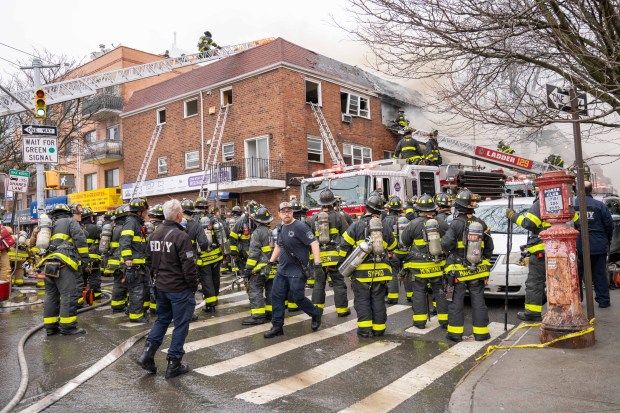 Firefighters respond to a fire on College Point Blvd. near Avery Ave. in Flushing on Monday.