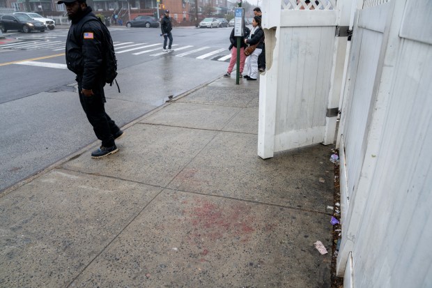 Blood is seen on the sidewalk at a bus stop on 94th Street in East Elmhurst on Monday after a random stabbing.