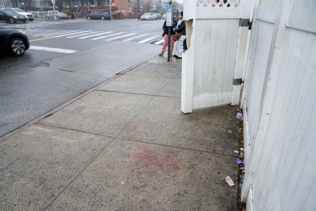 Blood is seen on the sidewalk near a bus stop at 94th St. and 23rd Ave. in East Elmhurst on Monday after a 30-year-old woman was stabbed in an unprovoked attack.