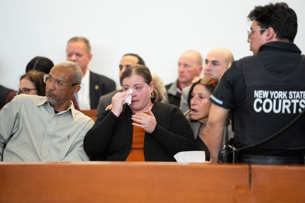 Minerliz Soriano's childhood friend Kimberly Ortiz, middle, wipes a tear along side Mineralizes father Luis Soriano, left during the sentencing of Joseph Martinez (Jupiter Joe) for the 1999 murder of 13-year-old Minerliz Soriano Thursday, March 26, 2026 in the Bronx, New York. (Barry Williams/ New York Daily News)
