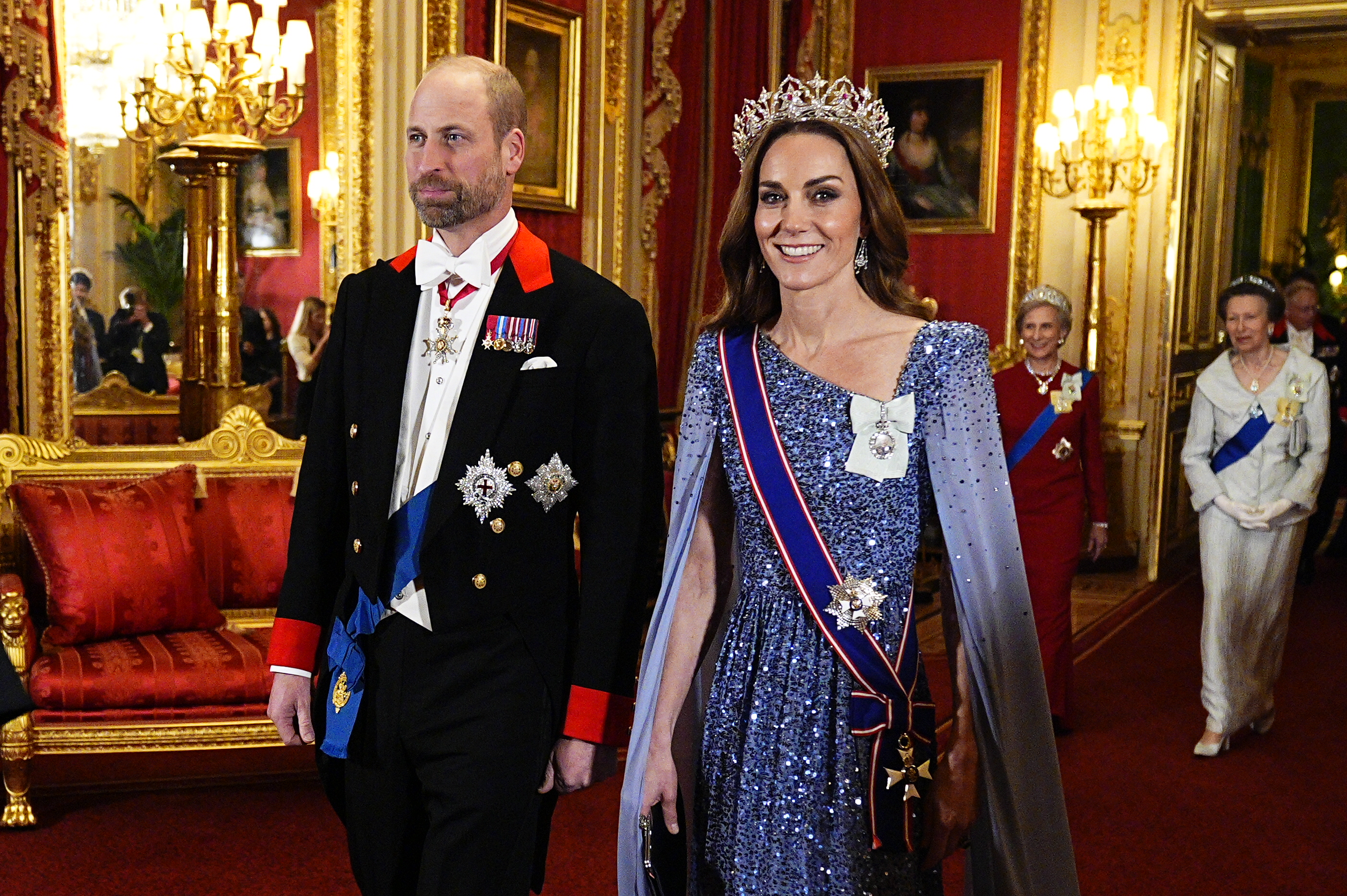 Prince William wearing a black tux and Princess Kate wearing a blue sequined gown and tiara