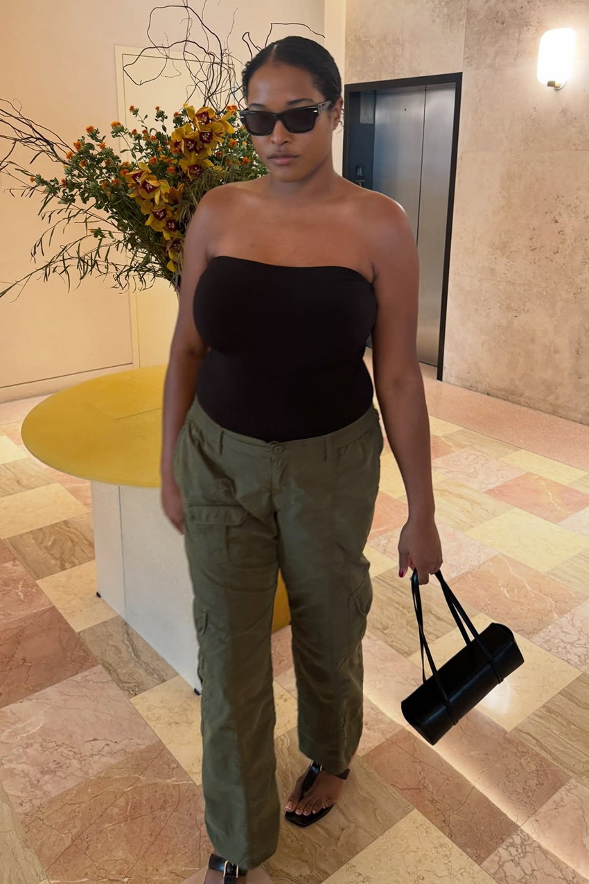 a woman wearing a black tube top, green cargo pants, and black thong sandals