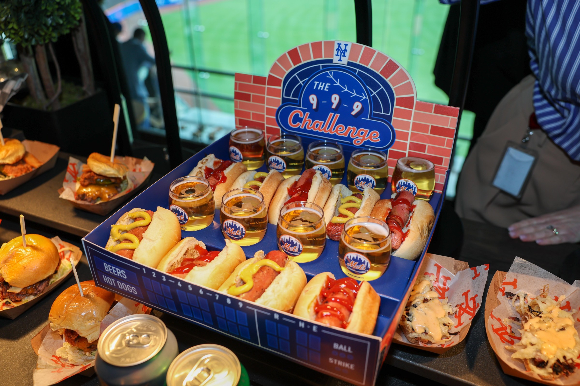 A cardboard tray of hot dogs and beers.