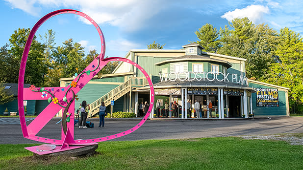 A pink heart sculpture stands on the green lawn of the the Woodstock Playhouse as people line up to attend the Woodstock Film Festival