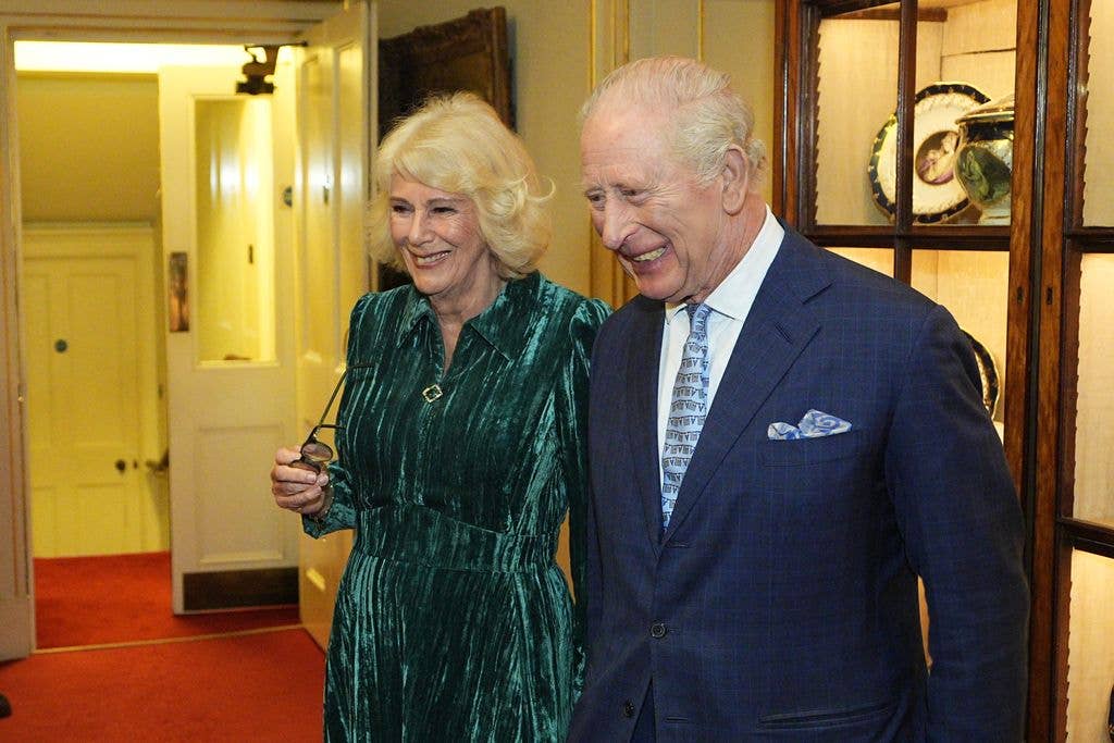Queen Camilla and King Charles III laugh as they attend a reception for authors, members of the literary community and representatives from the Queen's Reading Room to celebrate the first recipients of the Queen's Reading Room Medal at Clarence House on March 25, 2026 in London, 