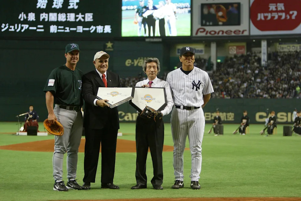 Former New York Mayor Rudolph Giuliani and Japan's Prime Minister Junichiro Koizumi stand with commemorative home plate alongside New York Yankee Hideki Matsui and Tampa Bay Devil RayTino Martinez.