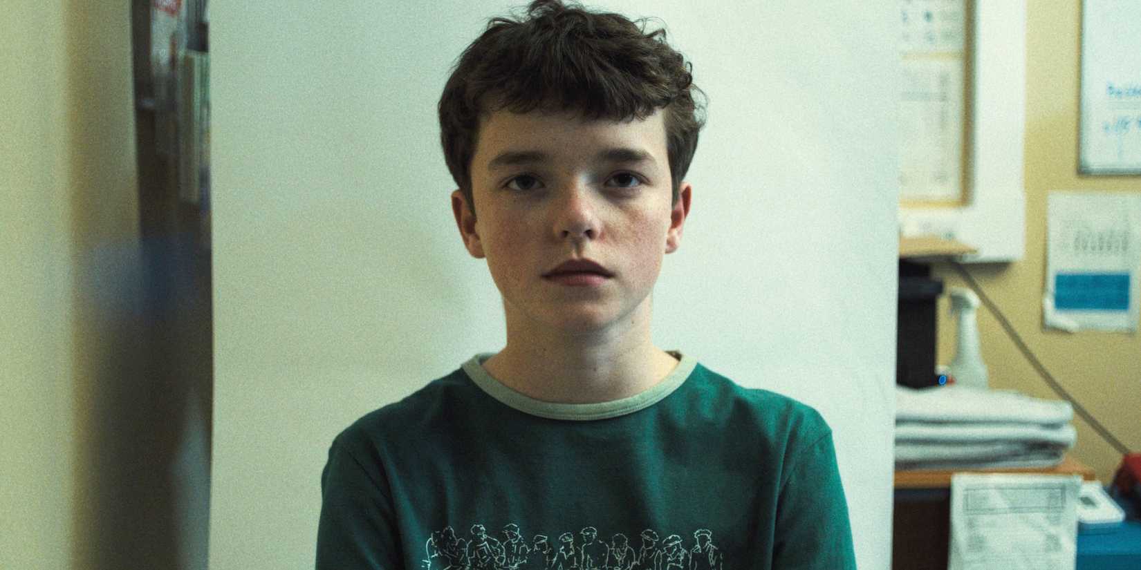 Owen Cooper sat wearing a green t-shirt in 'Adolescence'