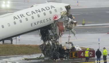 Officials investigate the site, Monday, March 23, 2026, where an Air Canada jet came to rest after colliding with a Port Authority firetruck at LaGuardia Airport, shortly after landing Sunday night in New York. (AP Photo/Seth Wenig)