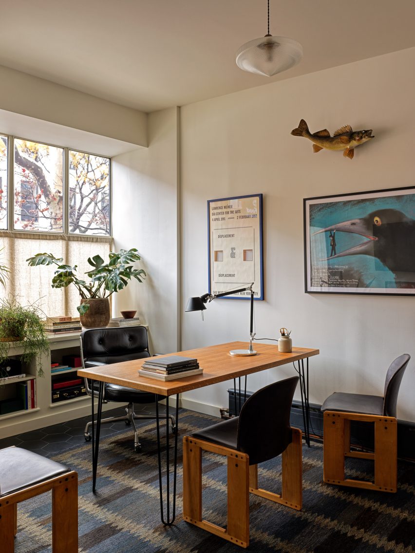 A curated art collection and patterned rugs add colour to a compact space