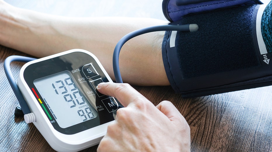 Man checks blood pressure monitor and heart rate monitor
