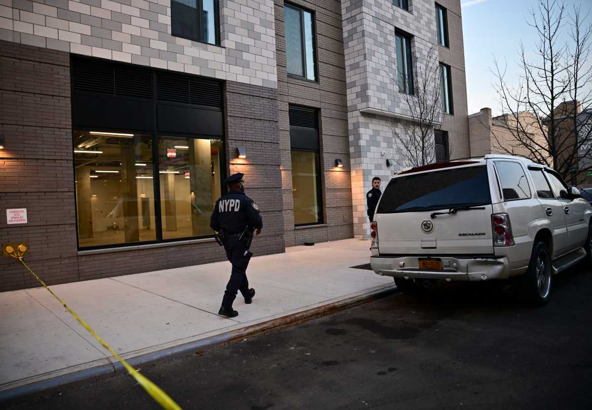 police officer walks by scene of brooklyn shooting