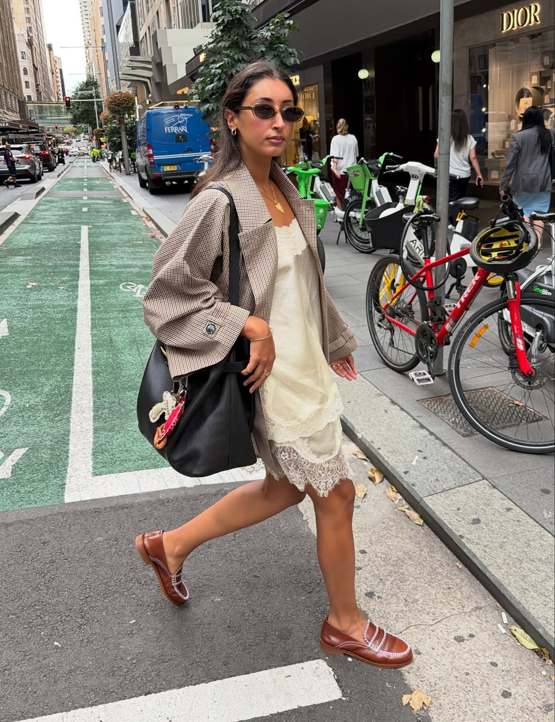 Woman wearing a lace slip dress and oversize blazer.