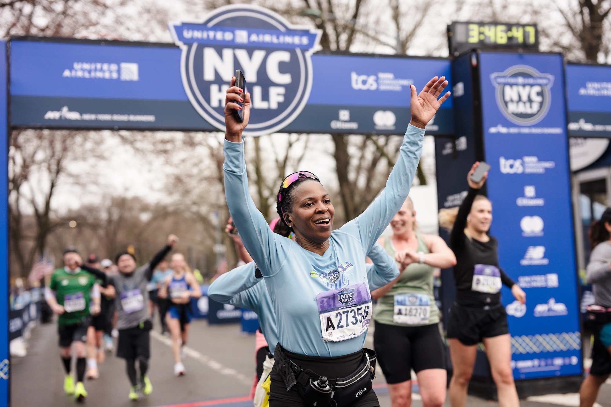 Runner with hands up at the finish line of the 2025 United Airlines NYC Half