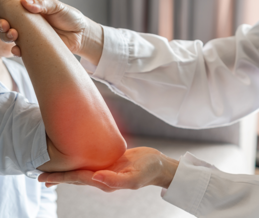 A provider treating a patient's elbow pain, with the elbow shaded in red to indicate pain.