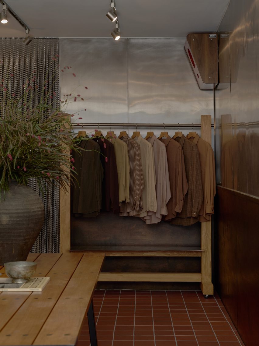 Clothing displayed on a rail against a stainless steel wall