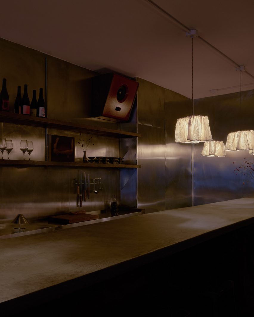 A concrete bar counter surrounded by stainless steel walls