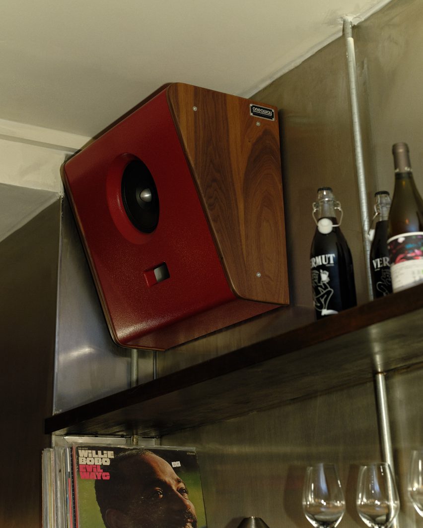 Red One-A-Way speaker mounted above shelving