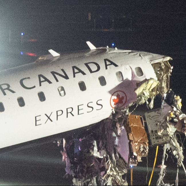 Air Canada Express airplane with a severely damaged nose at night.