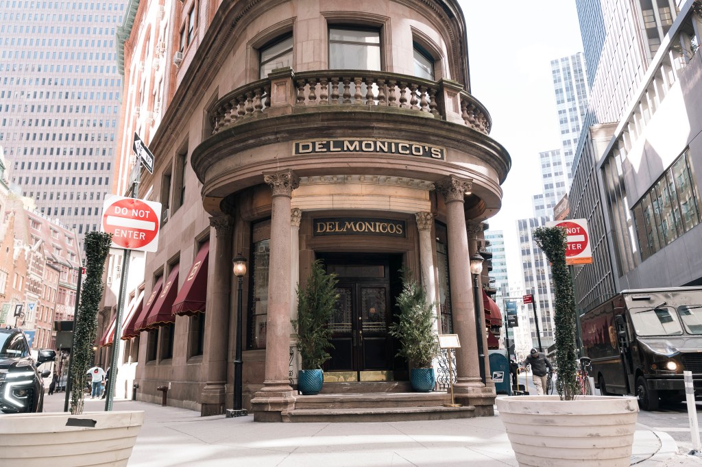 Delmonico's restaurant and steakhouse, a historic building with large ornate columns, located on a street corner in New York City.