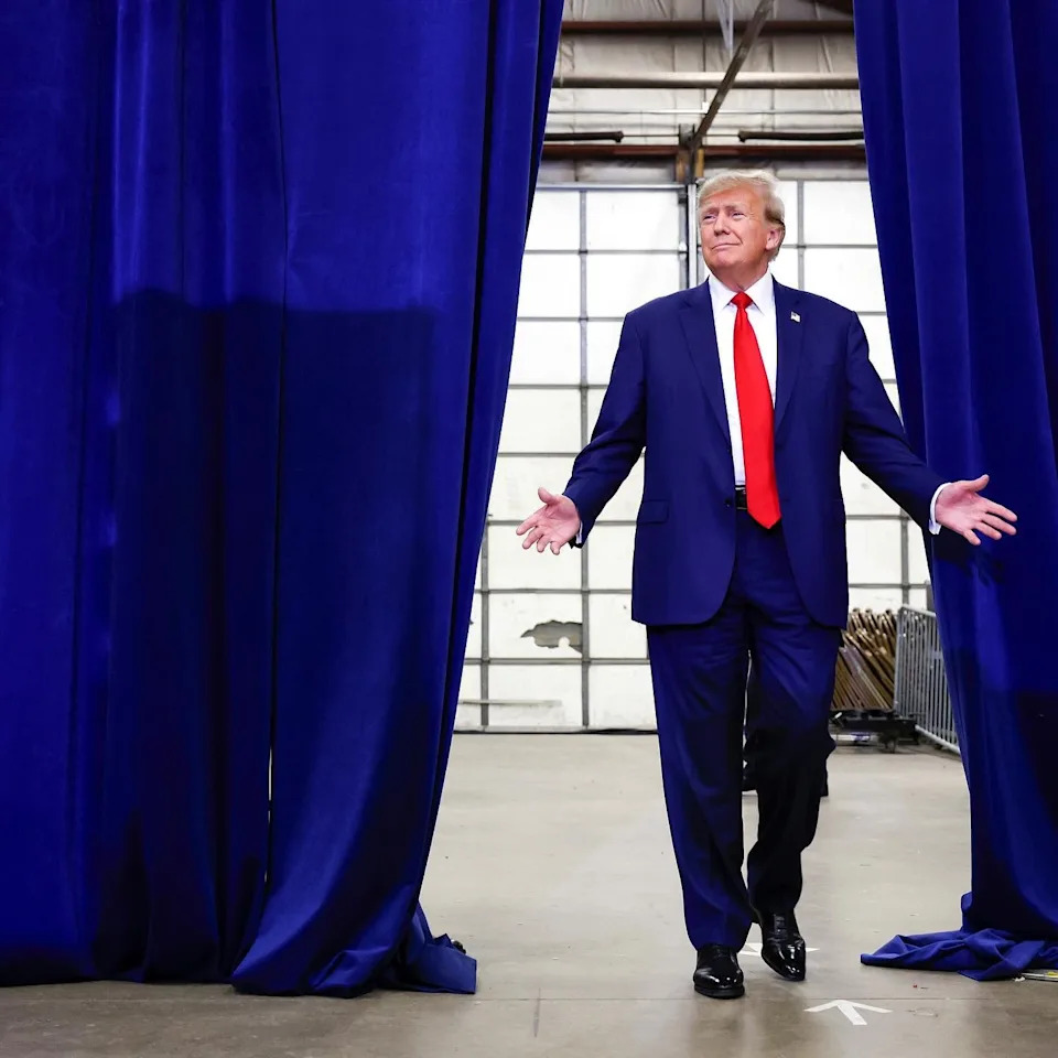 Making a bold entrance, Donald Trump arrives in his go-to high-low wardrobe staple: the tailored navy blazer and signature red silk tie.