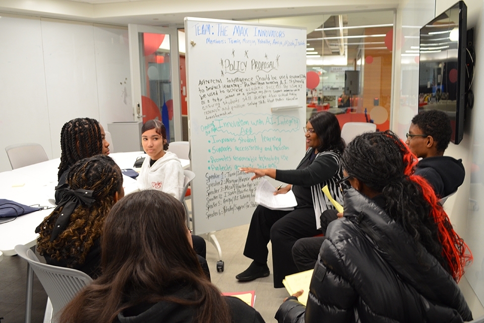 Student listening attentively as lady writes on board 