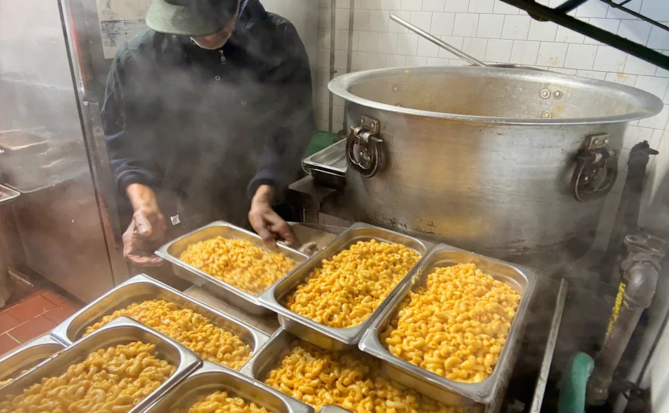 Tins of mac and cheese tacked atop each other at Datz Deli.