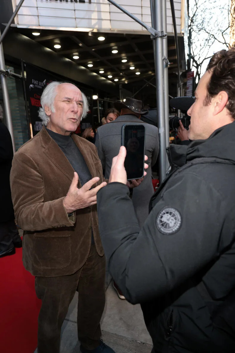 Man being interviewed on red carpet. 