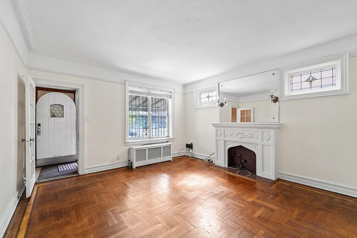 living room with white walls, mantel, stained glass