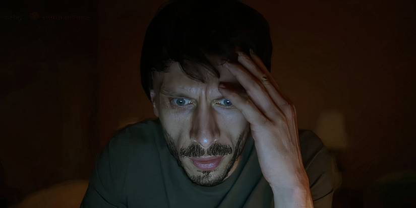 Donny staring at his computer in the dark looking concerned in Baby Reindeer.