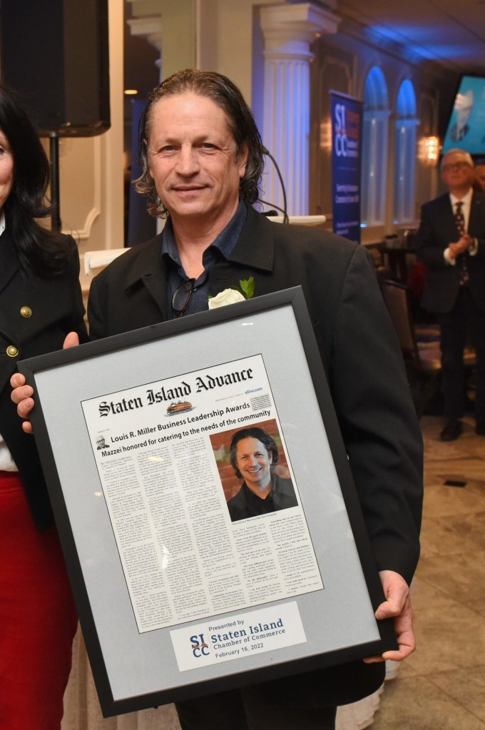 mazzei in 2022 holding a framed article recognizing his being honored by the staten island chamber of commerce