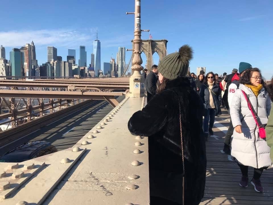 Emma Kershaw standing on bridge looking over Manhattan