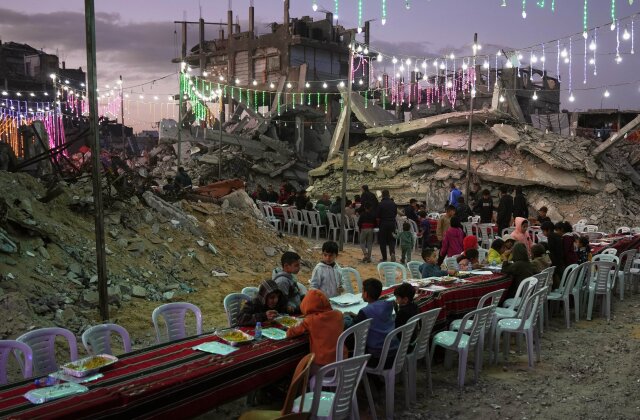 Palestinians sit at a long table amid the rubble of destroyed buildings as they gather for iftar, the fast-breaking meal, during the Muslim holy month of Ramadan in Khan Younis, Gaza Strip, Thursday, Feb. 19, 2026. (AP Photo/Abdel Kareem Hana)