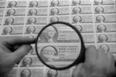A ration stamp for one unit of gasoline seen through a magnifying glass