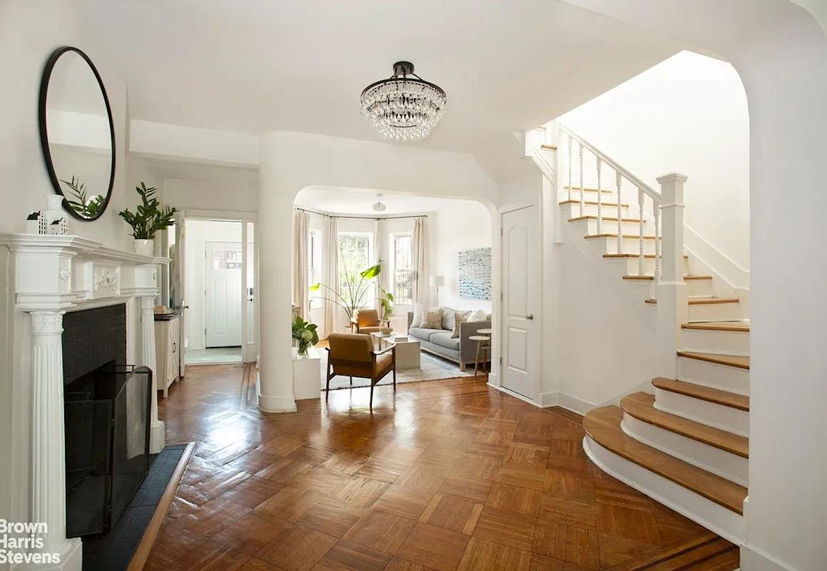 middle parlor with staircase and a columned mantel painted white
