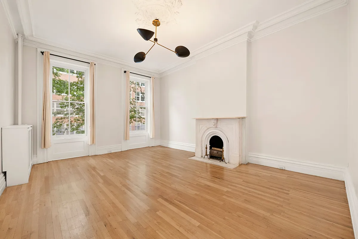 a parlor with white walls, a marble mantel