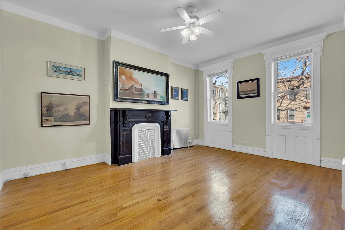 room with mantel, ceiling fan