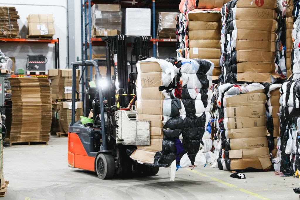 Employees sort clothing by material and color at Helpsy's facility in Eatontown