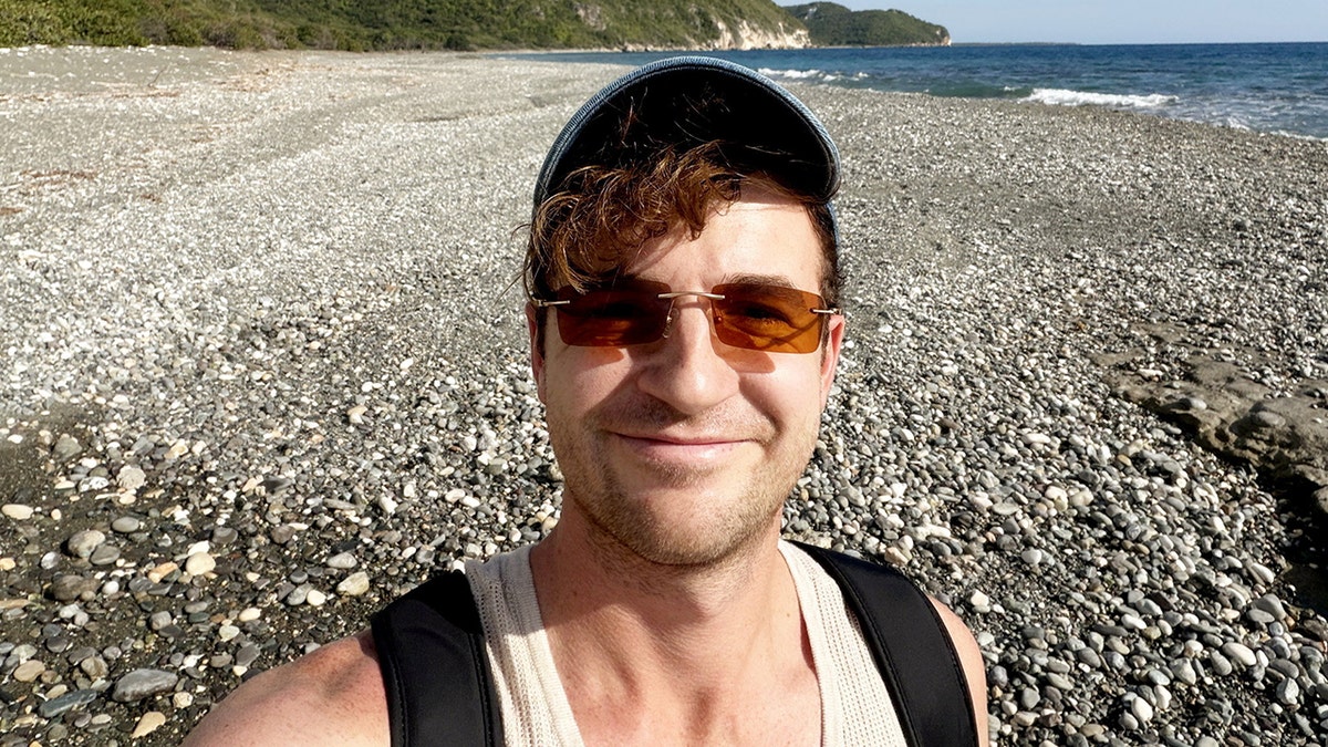 Kevin Droniak wearing sunglasses and a hat at the beach in Jamaica.